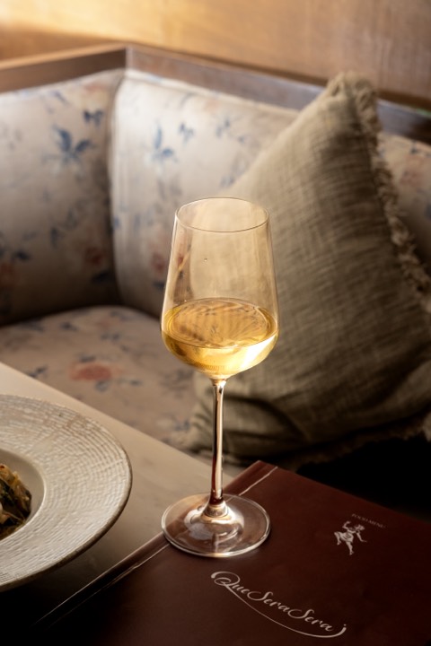 A glass of wine by the window at Que Sera Sera